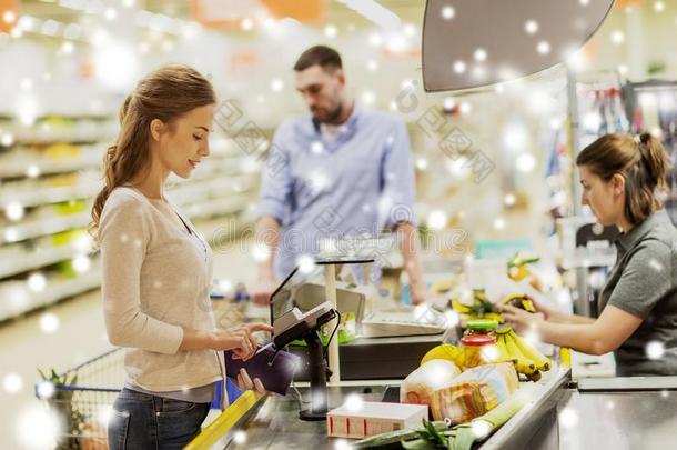 女人购买食物在食品杂货店商店现金登记