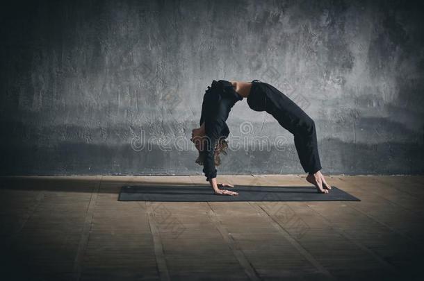 美丽的女人练习<strong>卖艺</strong>人身体向后仰作弓状的姿势瑜伽瑜珈的任何一种姿势乌尔达瓦Dhanur瑜珈的任何一种姿势