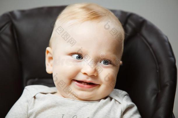 婴儿采用小孩吃饭时所用的高脚椅子和采用terested看和宽阔的微笑