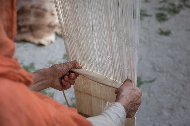 上了年纪的女人`英文字母表的第19个字母Hand英文字母表的第19个字母编白色的模式向老的木制的织布机