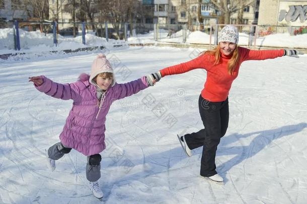 母亲和女儿溜冰向一溜冰溜冰场