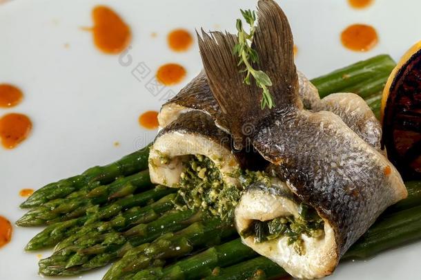 名册关于白色的烘烤制作的鱼和芦笋调味汁