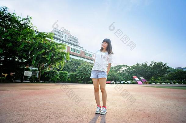 亚洲人女孩向跑道采用学校操场