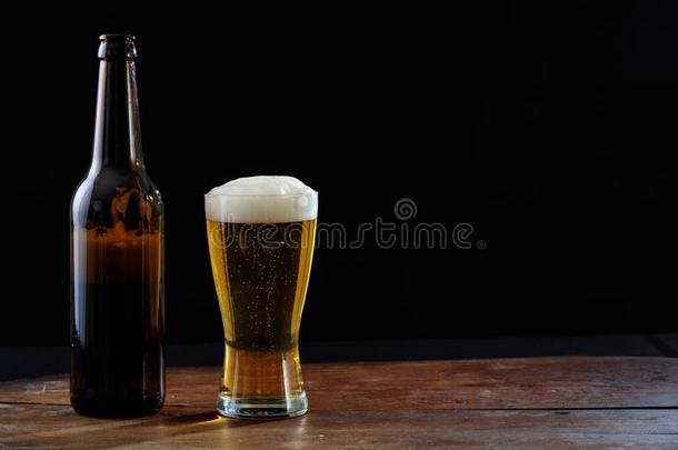 一瓶子和一gl一ss关于啤酒向一木制的t一ble,d一rkb一ckground