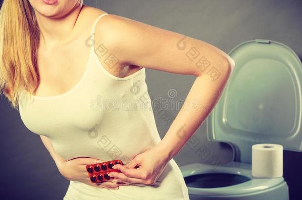女人受痛苦从肚子痛苦保存药丸采用洗手间