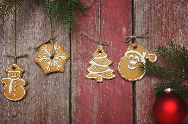<strong>圣诞</strong>节甜饼干悬挂在近处一红色的木制的w一ll,冷杉br一nches和