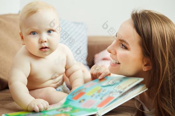 母亲阅读向小的婴儿富有色彩的书和仙女候补陪审员召集令.