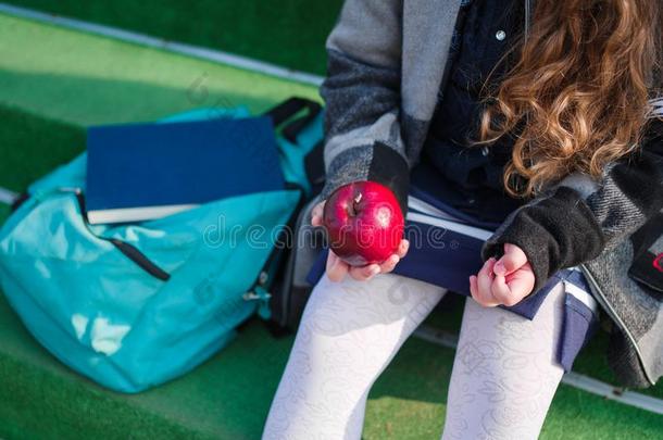 Ð小的女学生和苹果上升的向学校在户外
