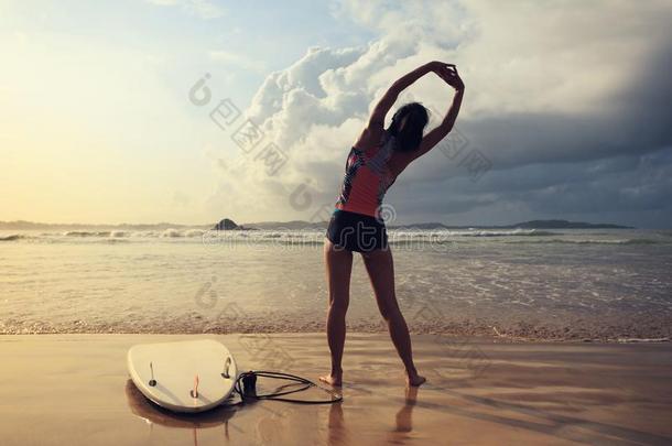 女人冲浪运动员准备动作的在上面向指已提到的人海滩