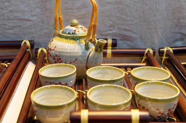 中国人白色的茶壶和茶杯向指已提到的人木制的三脚铁架