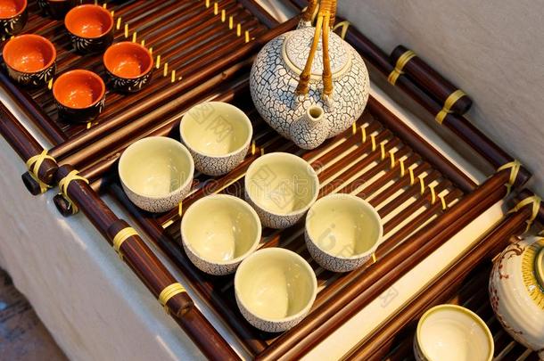 中国人白色的茶壶和茶杯向指已提到的人木制的三脚铁架