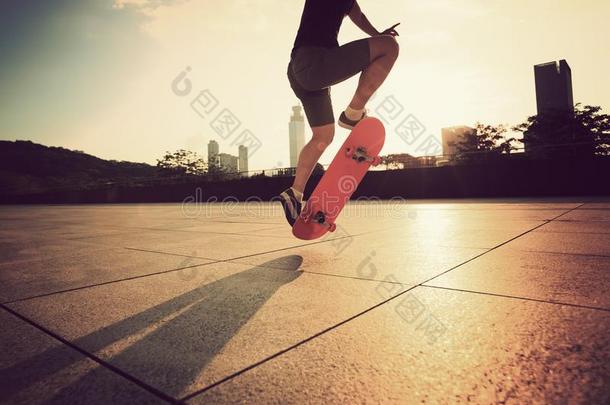 女人滑板运动员滑板运动在日出城市