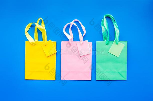 有色的纸购物袋模式向蓝色背景顶看法