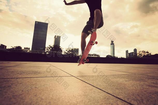 女人滑板运动员滑板运动在日出城市