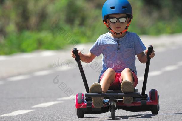 幸福的男孩起立向悬滑板或陀螺仪和小型赛车入径