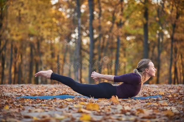 美丽的年幼的女人练习瑜伽<strong>瑜珈</strong>的任何一种姿势Salabh<strong>瑜珈</strong>的任何一种姿势蝗虫便壶