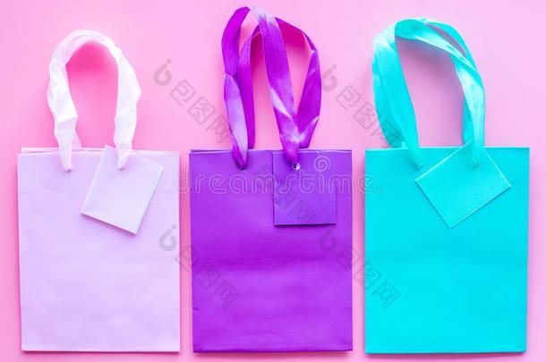 有色的纸购物袋模式向粉红色的背景顶看法