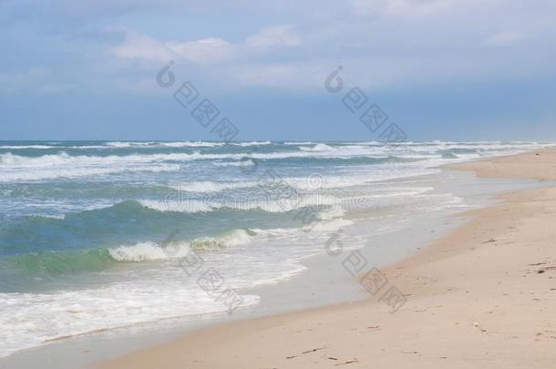 海海岸波旋<strong>转</strong>的向沙的海滩,有暴风雨的<strong>多云</strong>的日出