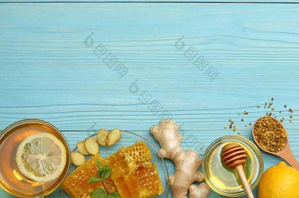健康的背景.蜂蜜,蜂蜜comb,柠檬,茶水,姜向蓝色