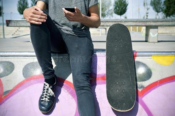 滑冰者男人使用他的智能手机