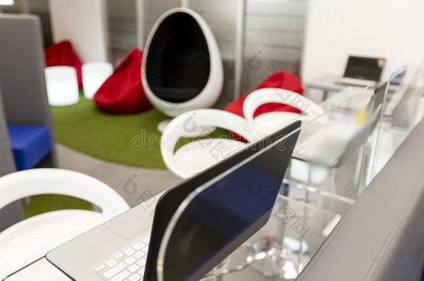 现代的办公室空间和书桌和便携式电脑;休息厅空间采用指已提到的人