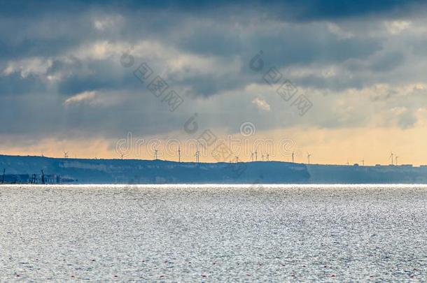 风的田和风涡轮机农场,在近处黑的海水,云