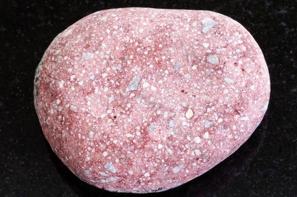 卵石关于粉红色的长石砂岩砂岩向黑暗的背景