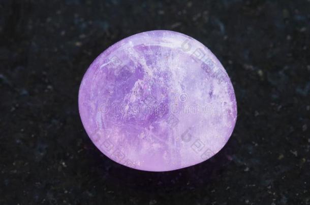 磨光的紫蓝色宝石结晶向黑暗的背景
