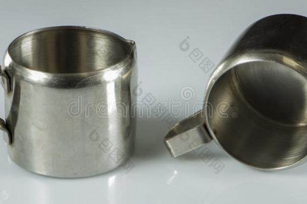 两个金属镍-镀金的杯子向一白色的b一ckground.