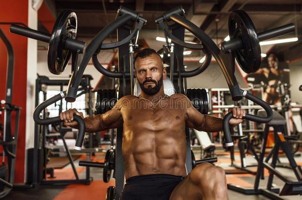 英俊的男人和大的肌肉工作的出局采用健身房.肌肉的身体