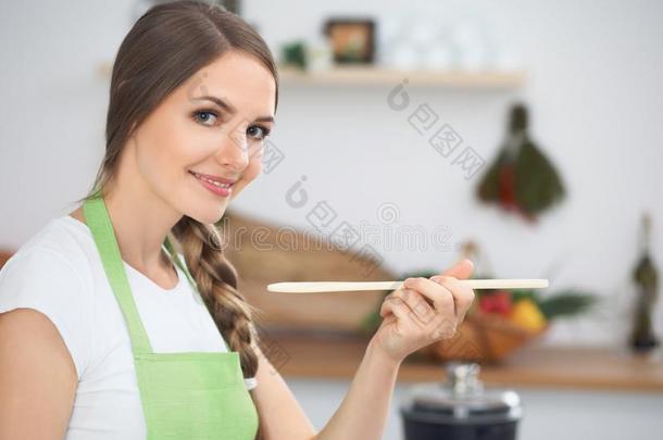 年幼的女人烹饪术采用一厨房.家庭主妇t一st采用g汤在旁边木材