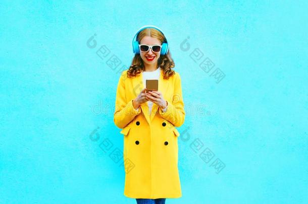 时尚女人和智能手机倾听向音乐采用耳机