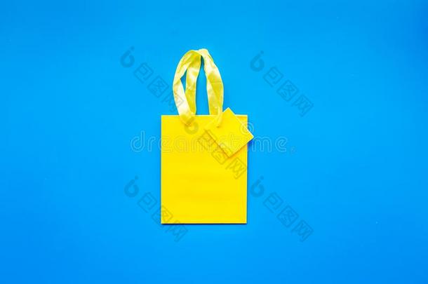 黄色的明亮的购物袋向蓝色背景顶看法共空间