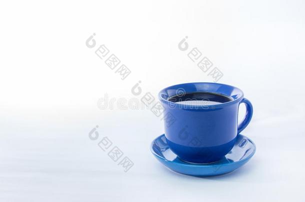 蓝色马克杯和冒热气的热的咖啡豆.软的烟.白色的背景.