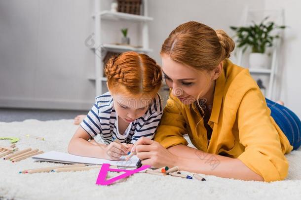 母亲和女儿绘画和用彩色蜡笔画