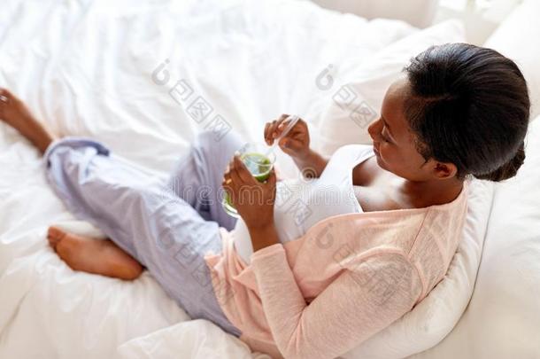 怀孕的女人喝饮料蔬菜果汁采用床