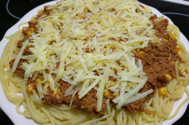 热的新鲜的意大利面条波伦亚的形成顶部和搓碎的切德干酪奶酪