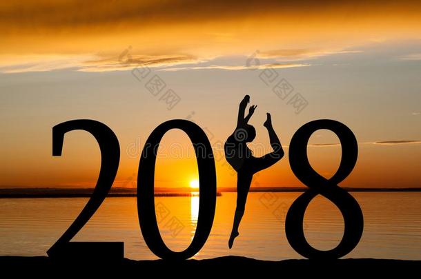 2018新的年轮廓关于女孩跳舞在金色的日落