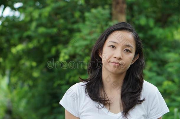 亚洲人女人长的头发和面部的压抑绿色的自然后座议员