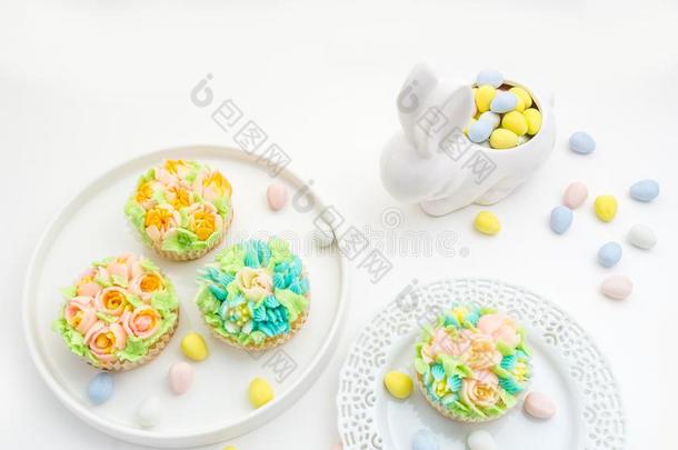 复活节主题装饰纸杯蛋糕向白色的背景和一兔子