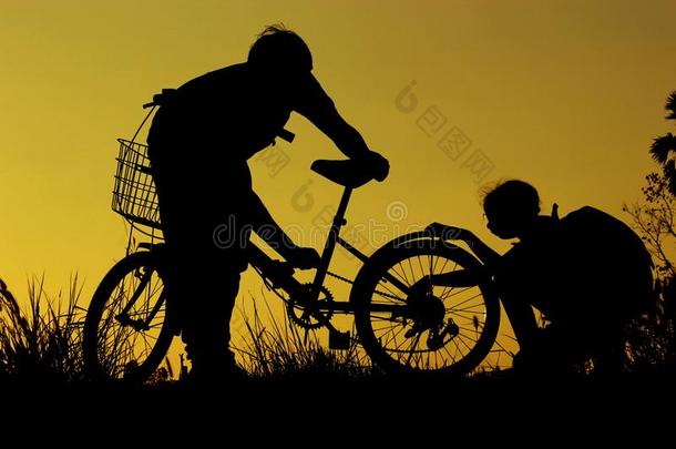 小的男孩和女孩骑马自行车在日落,积极的小孩运动,一