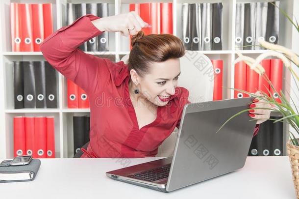 生气的商业女人<strong>跳动</strong>便携式电脑和她拳