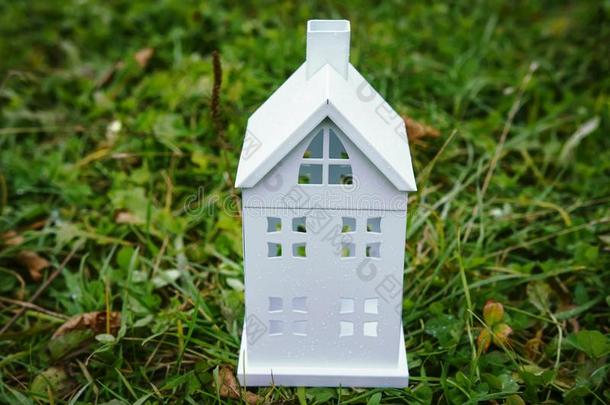 家观念.白色的房屋模型向绿色的草.保险关于霍