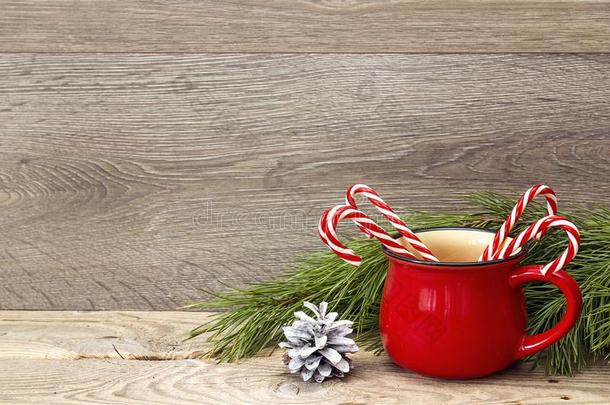 红色的杯子和有条纹的圣诞节糖果茎反对木制的后面