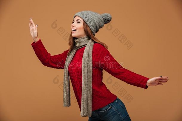 幸福的年幼的女人采用红色的愈合毛衣和灰色帽子pos采用gon-vehicleequipment车上装备