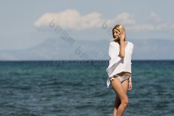 Î隆德女人穿着白色的底部比基尼式游泳衣和长的衬衫