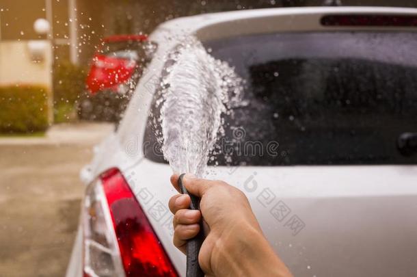 洒和水向洗指已提到的人汽车在旁边手.