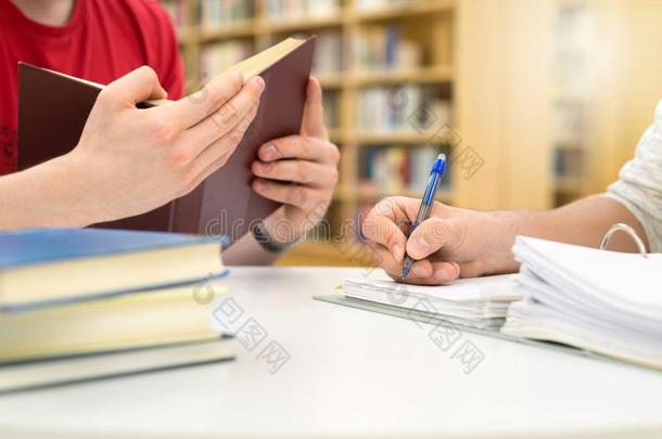 两个学生学习,阅读和文字采用图书馆.