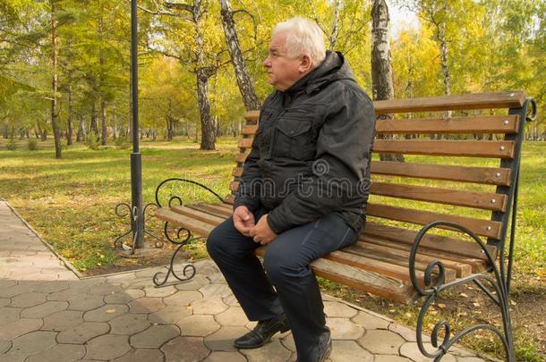 指已提到的人<strong>孤单</strong>的灰色-有毛发的老的男人,静止的向一木制的长凳采用一P一r