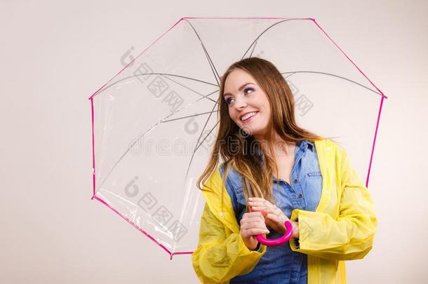 女人使人疲乏的不透水的上衣在下面雨伞